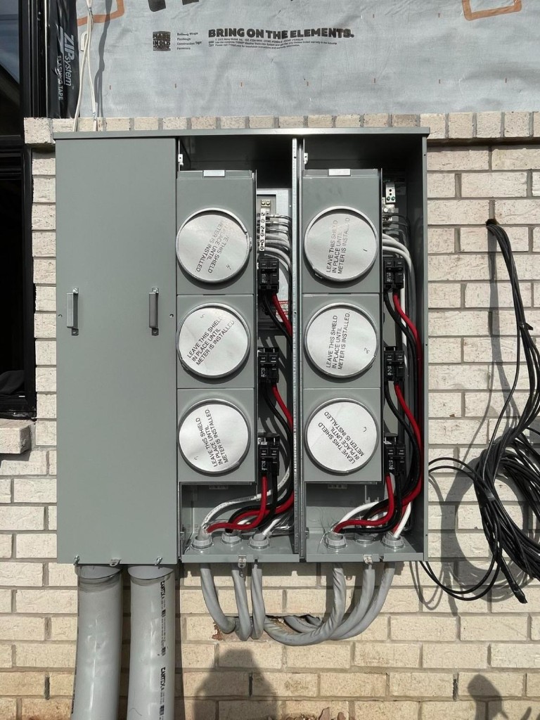 Multi-meter electrical service installation on brick exterior