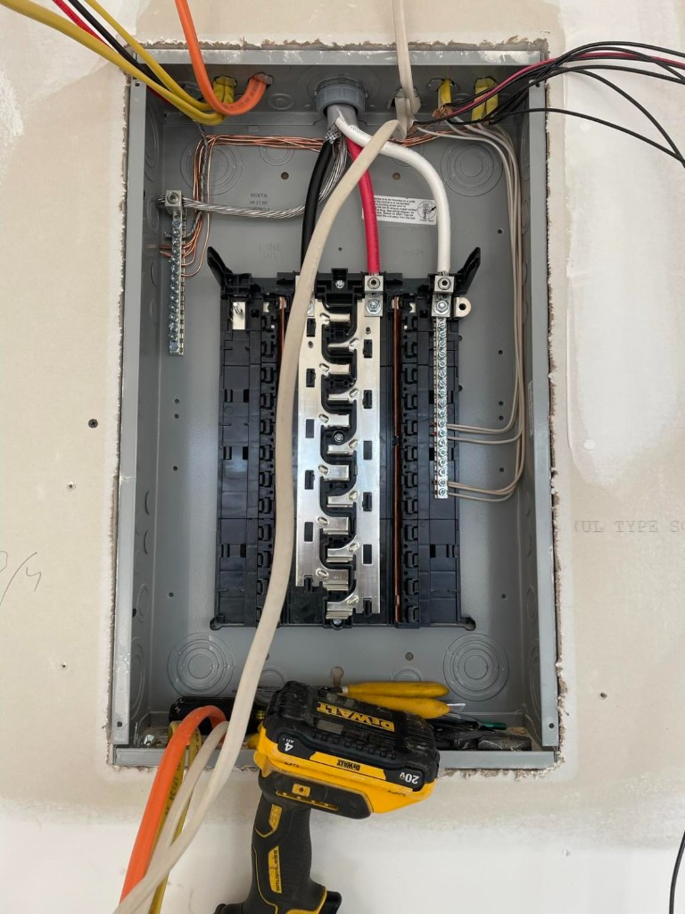 Panel install in progress with feeder wires and tools